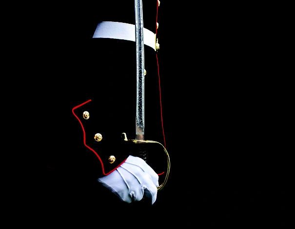 Marine NCO sword held in a white-gloved hand against dress blues